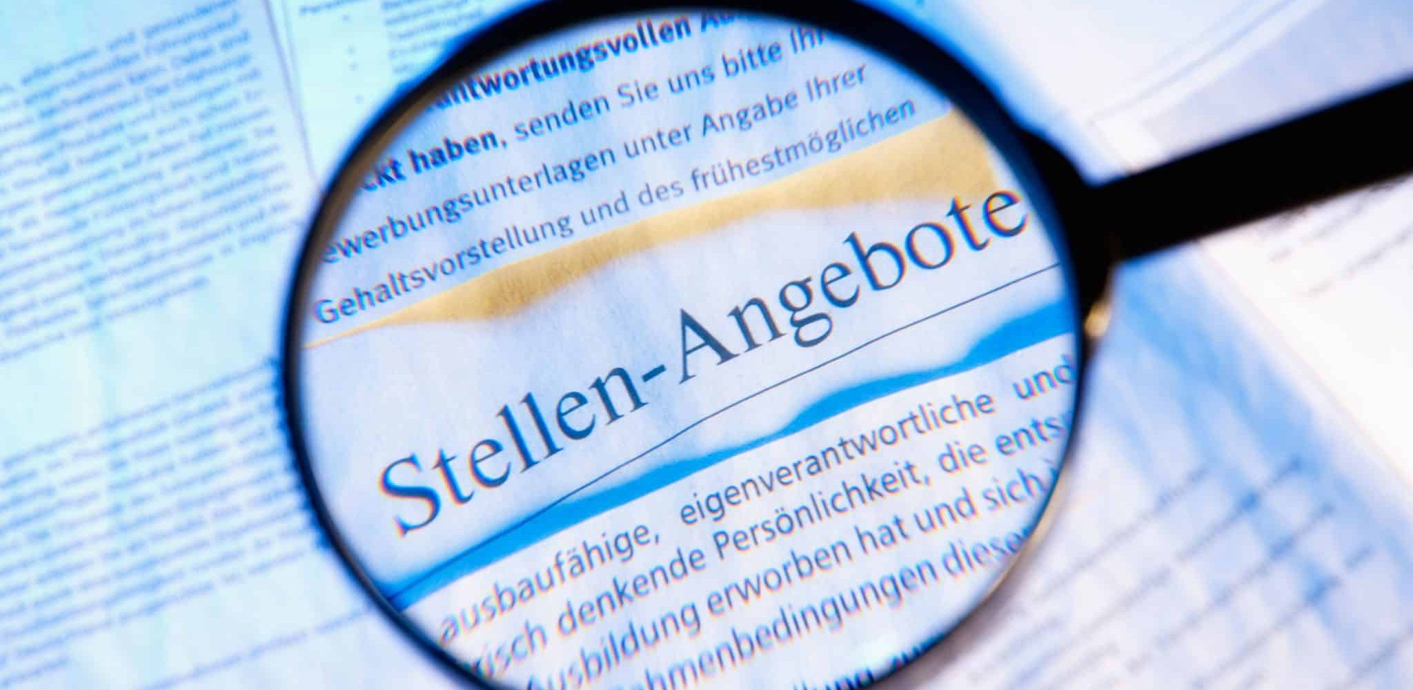 Bild von Zeitung mit Lupe und vergrößerter Überschrift: Jobs & Stellenangebote
